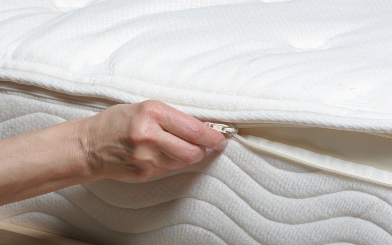 Close up view of latex mattress with organic cover being unzipped.